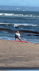 Woman performs surfboard lunge exercise on North Kuta beach