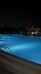 Empty pool glows blue at night in Serik, Turkey