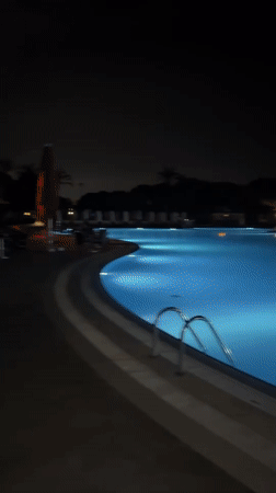 Empty pool glows blue at night in Serik, Turkey