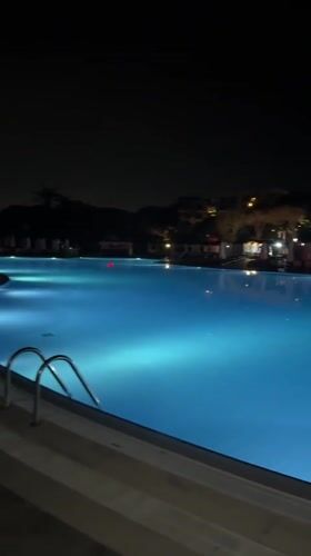 Empty pool glows blue at night in Serik, Turkey