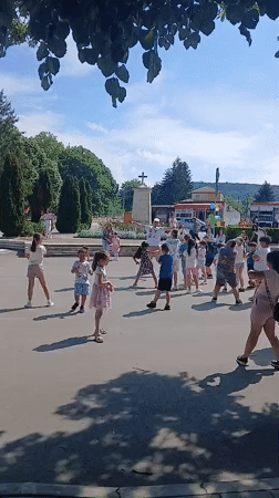 Children and adults gather for group activity in Bulgarian town square