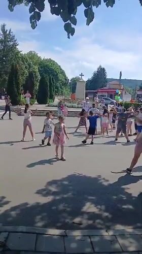 Children and adults gather for group activity in Bulgarian town square