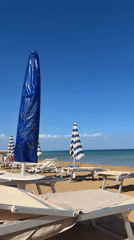 Beach scene captured in Noto, Italy with umbrellas and loungers