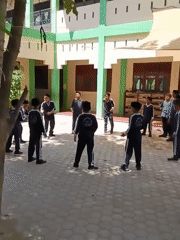School children gather in courtyard formations in Lhokseumawe