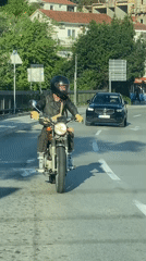 Motorcyclist rides vintage bike through Rafailovići, Montenegro streets