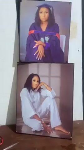 The video shows two framed photographs of the same young woman. The top photo is a graduation portrait. She is wearing a graduation cap and gown. She has curly hair and manicured fingernails. The bottom photo is a portrait of the same young woman wearing a white pantsuit and no shoes. She is posed sitting down with one hand resting on her knee.