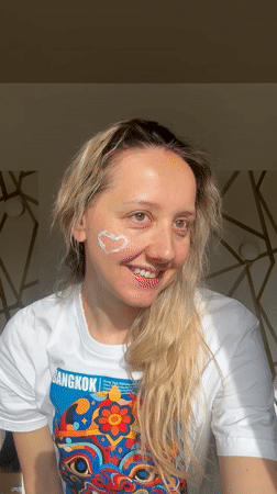 Woman poses with heart-shaped cream on cheek in Latvia