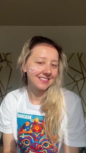 Woman poses with heart-shaped cream on cheek in Latvia