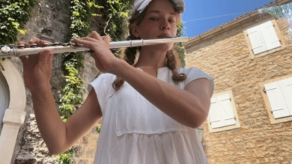 Street musician performs flute in historic Budva courtyards