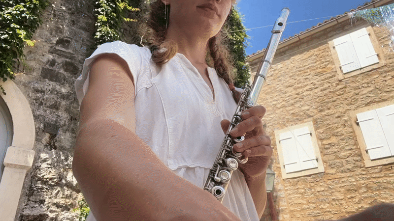 Street musician performs flute in historic Budva courtyards