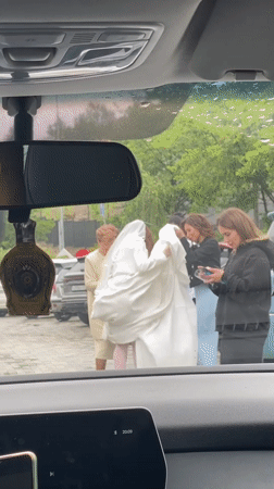 Wedding party assists bride during rainy day in Sochi