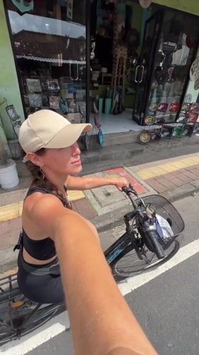 Tourist documents art installations while cycling through Tegallalang