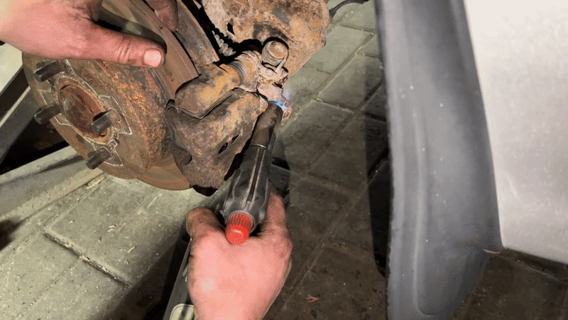 Mechanic uses torch on rusted brake caliper in Hrodna garage