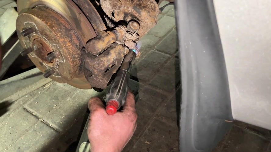 Mechanic uses torch on rusted brake caliper in Hrodna garage