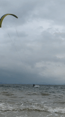 Kitesurfers ride choppy waves under cloudy skies in Vietnam