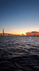 Gazprom Arena glows red over Saint Petersburg's waterfront at dusk