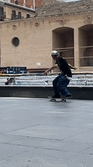 Skateboarder performs tricks in Barcelona plaza