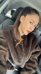 Woman in fur coat smiles at camera in Sofia car