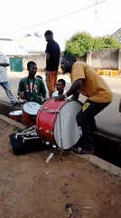 Street musicians perform with drums, trumpets in ceremonial attire