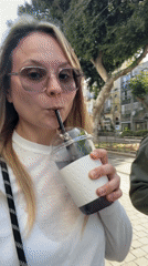 Couple enjoys afternoon beverages, applies sunscreen on Tel Aviv sidewalks