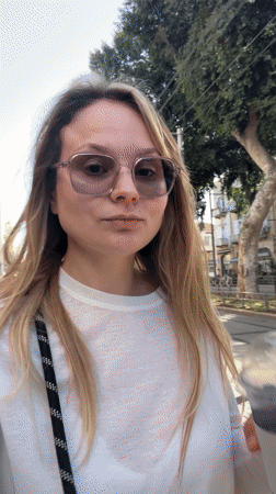 Couple enjoys afternoon beverages, applies sunscreen on Tel Aviv sidewalks