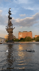 Motorboat passes bronze statue on Moscow waterway