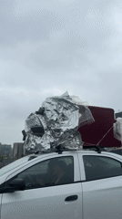 White car travels highway with loaded roof rack near La Lonja