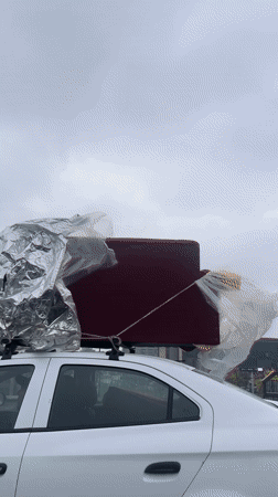 White car travels highway with loaded roof rack near La Lonja
