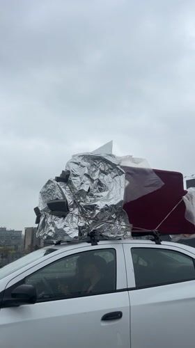 White car travels highway with loaded roof rack near La Lonja
