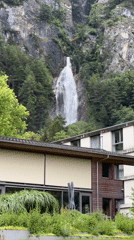 Tourist documents waterfall hike in Swiss mountain village