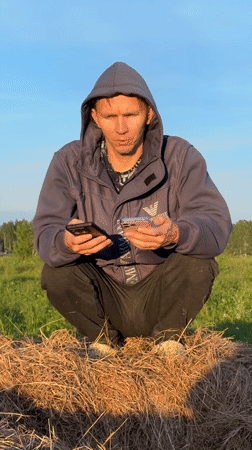Two people gather in rural Russian field during golden hour