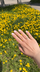Woman photographed in Russian dandelion field wearing wedding rings