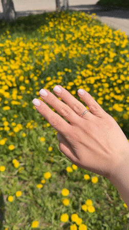 Woman photographed in Russian dandelion field wearing wedding rings