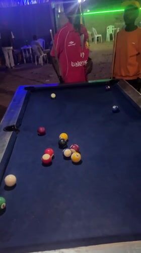 Men play nighttime pool game at Gura Top establishment