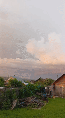 After-rain sunset captured across rural Novoilinsky gardens and backyards