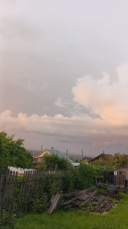 After-rain sunset captured across rural Novoilinsky gardens and backyards