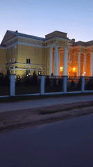 Dusk drive to a lit neoclassical building in rural Belarus