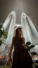 Tourists pose for nighttime photos at Petronas Twin Towers