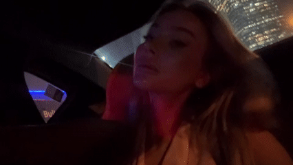 Woman travels by car through Dubai at night