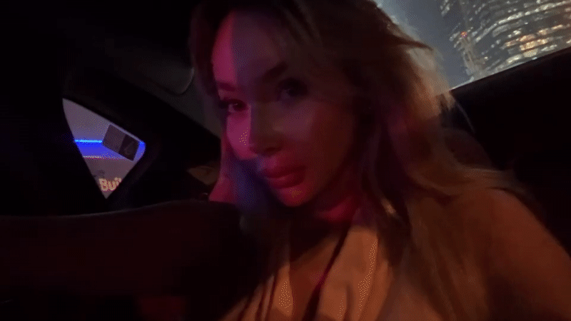 Woman travels by car through Dubai at night