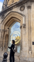 Ornate golden clock and Gothic architecture in central Cambridge