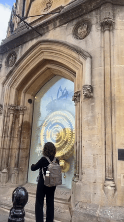 Ornate golden clock and Gothic architecture in central Cambridge