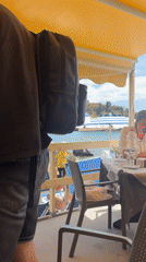Tourists enjoy dining and beach activities in Taormina, Italy