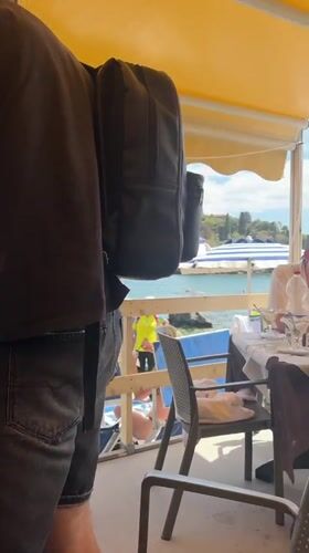 Tourists enjoy dining and beach activities in Taormina, Italy
