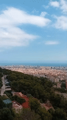 Panoramic Barcelona cityscape captured from hilltop during afternoon hours