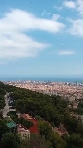 Panoramic Barcelona cityscape captured from hilltop during afternoon hours