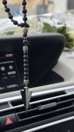 Beaded car accessory with pendant observed in Milan vehicle