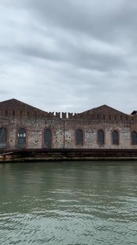 Historic Venice canal buildings filmed from boat on overcast morning