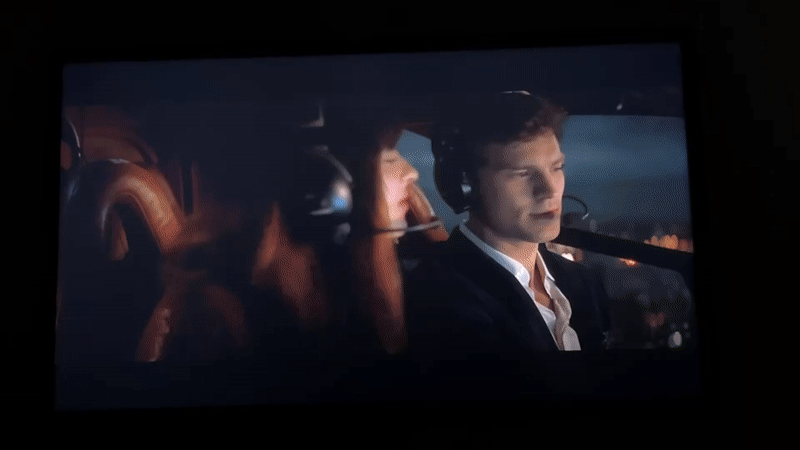 Person watches helicopter scenes, "Fifty Shades" on screen