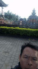Evening documentation captures Balinese temple, sacred tree, parked vehicle